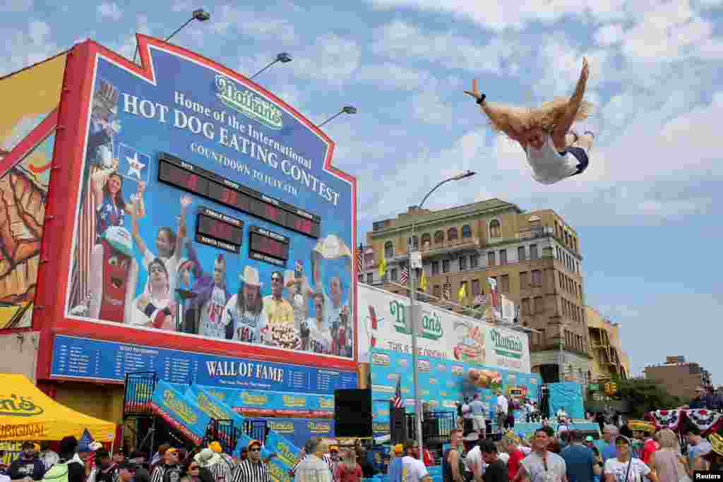 뉴욕 브루클린에서 진행된 독립기념일 기념 핫도그먹기 대회 참가자가 트렘폴린에 뛰어들고 있다.