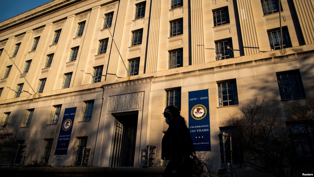 资料照片：一名女子走过位于华盛顿的美国司法部大楼。（2020年12月15日）(photo:VOA)