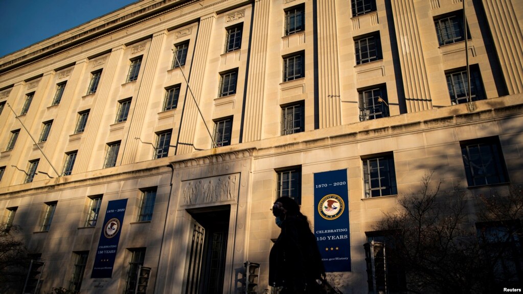 资料照片：2020年12月15日，一名女子走过位于华盛顿的美国司法部大楼。（路透社照片）(photo:VOA)