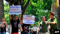 Người biểu tình mặc áo phản đối tuyên bố đường "lưỡi bò chín đoạn" và trương biểu ngữ chống Trung Quốc tại Hà Nội hồi tháng 7/2016. Bộ Ngoại giao tại Hà Nội vừa yêu cầu các doanh nghiệp tại đây tuân thủ quy định và tôn trọng chủ quyền biển đảo của Việt Nam. 