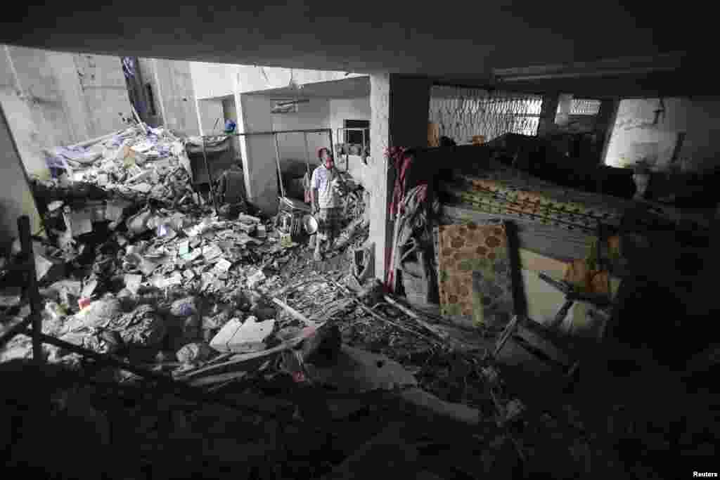 A Palestinian man inspects the office of a charitable organization which police said was targeted in an Israeli airstrike, in the southern Gaza Strip, July 15, 2014.