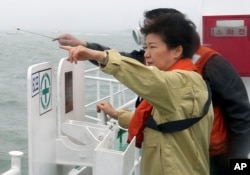 FILE - South Korean President Park Geun-hye looks at the site where the Sewol sank from aboard a Coast Guard ship in waters off the southern coast near Jindo, South Korea, Thursday, April 17, 2014.