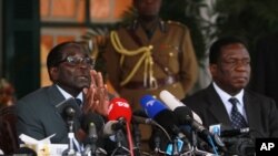 FILE: Zimbabwean President Robert Mugabe, left, and Defense Minister Emmerson Mnangagwa, at State House press conference, Harare, July, 30, 2013.