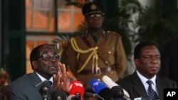 FILE - Zimbabwean President Robert Mugabe, left, and Defense Minister Emmerson Mnangagwa, at State House press conference, Harare, July, 30, 2013.