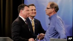 Senate candidates from left, Todd Rokita, Luke Messer and Mike Braun speak with each other following the Indiana Republican senate primary debate in Indianapolis, April 30, 2018.