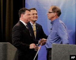 Senate candidates from left, Todd Rokita, Luke Messer and Mike Braun speak with each other following the Indiana Republican senate primary debate in Indianapolis, April 30, 2018.