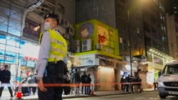 A police officer stands guard outside a pet store that was closed after some pet hamsters were, authorities said, tested positive for COVID-19, in Hong Kong, Tuesday, Jan. 18, 2022. (AP Photo/Kin Cheung)