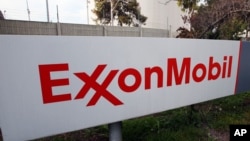 FILE - A sign for the ExxonMobil refinery in Torrance, California, Jan. 30, 2012