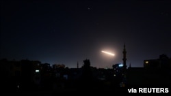 Light in the sky is seen in Damascus, Syria, in this handout released by SANA on Feb. 24, 2020. 