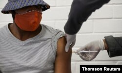 FILE - A volunteer receives an injection from a medical worker during the country's first human clinical trial for a potential vaccine against the novel coronavirus, at Baragwanath Hospital in Soweto, South Africa, June 24, 2020.