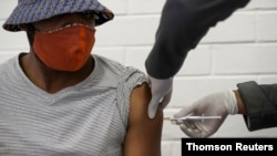 FILE - A volunteer receives an injection from a medical worker during the country's first human clinical trial for a potential vaccine against the novel coronavirus, at Baragwanath Hospital in Soweto, South Africa, June 24, 2020.