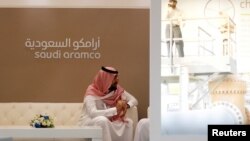 Seorang karyawan Saudi Aramco duduk di stan Saudi Aramco dalam sebuah pameran industri minyak di Manama, Bahrain, 27 September 2016.