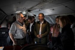 Howard Buffett, left, talks to Colombia's President Ivan Duque aboard an air force plane before departing from Bogota, Colombia, Jan. 29, 2020. Duque has vowed to slash cocaine production in half by the end of 2023.