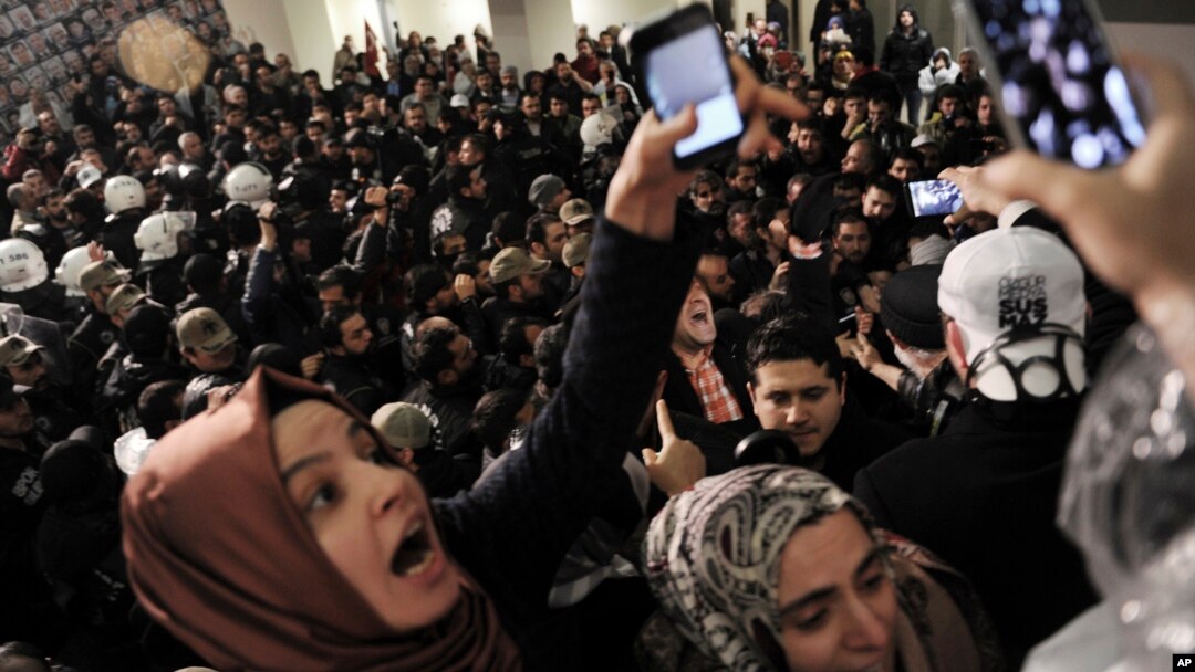 Journalists react as riot police enter the headquarters of Turkey's largest-circulation newspaper Zaman in Istanbul, March 4, 2016. The police raid came hours after a court placed it under the management of trustees on Friday. 