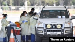 Health workers test the South Australian public at a drive-through coronavirus disease testing site in Adelaide, Nov. 19, 2020. 