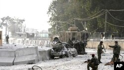 Afghan soldiers secure the scene of a suicide attack at the gate of an airport in Jalalabad, Nangarhar province east of Kabul, Afghanistan, February 27, 2012.