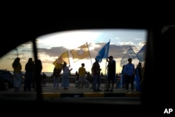 Miembros de un partido político se manifiestan un día antes de las elecciones generales, en Montevideo, Uruguay, el sábado 26 de octubre de 2024. (Foto AP/Natacha Pisarenko)