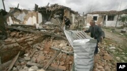 Villagers check damaged houses in Gerdec, Albania, March 17, 2008 after an explosion at a munitions depot. A U.S.-funded program assisted with cleanup. 