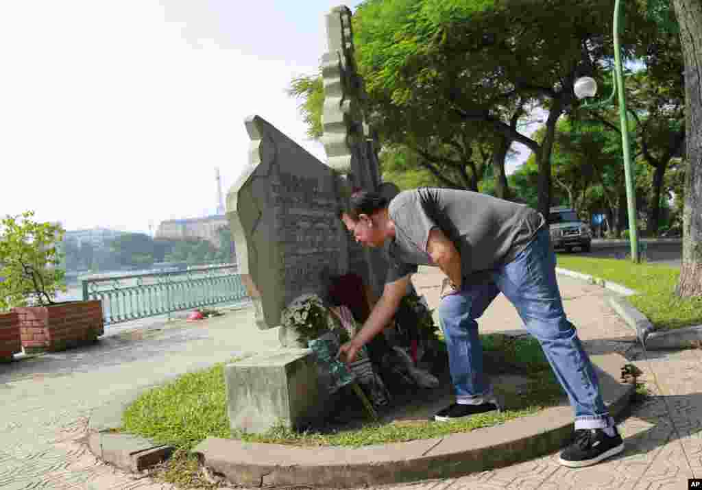 Victor Ramos, a Mexican man who has been living California for the past 35 years, lays flowers at the monument of U.S. Senator John McCain in Hanoi, Vietnam, Aug. 27, 2018.