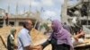 Un hombre y una mujer palestinos se saludan entre escombros en la Franja de Gaza el 21 de mayo de 2021, después de la tregua acordada entre Israel y Gaza.