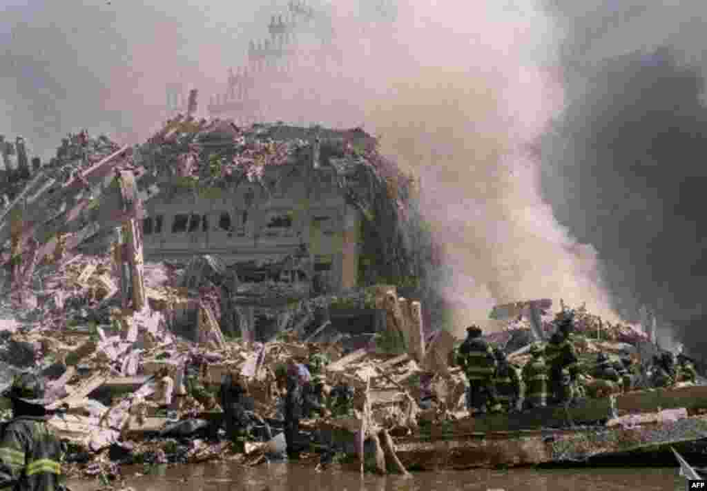 Firemen work in the rubble at the base of the World Trade Center in New York, Tuesday, Sept. 11, 2001 after terrorists crashed two hijacked airliners into the World Trade Center and brought down the twin 110-story towers. (AP Photo/Matt Moyer)