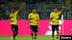 Ousmane Dembele de Dortmund, à gauche, célèbre avec ses coéquipiers Pierre-Emerick Aubameyang et Nuri Sahin après le deuxième but de leur équipe contre FC Bayern Munich lors de la Supercoupe DFL à Dortmund, Allemagne, 5 août 2017.