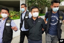 FILE - Ryan Law, second from right, being arrested by police officers in Hong Kong, June 17, 2021.