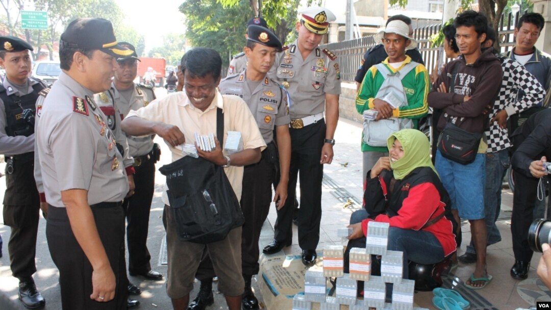 Pemeriksaan dan peringatan penukaran uang di pinggir jalan Surabaya untuk menghindari perdagangan uang palsu. (VOA/Petrus Riski)