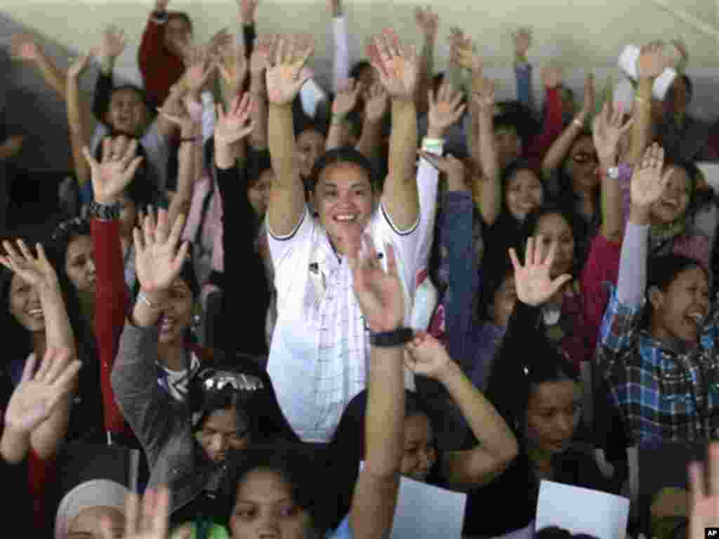 Overseas Filipino Workers (OFWs), fleeing the civil war in Syria, cheer upon arrival at the Ninoy Aquino International Airport via a chartered flight by International Organization for Migration Thursday Oct. 18, 2012 in Manila, Philippines. Of the 261 OFW