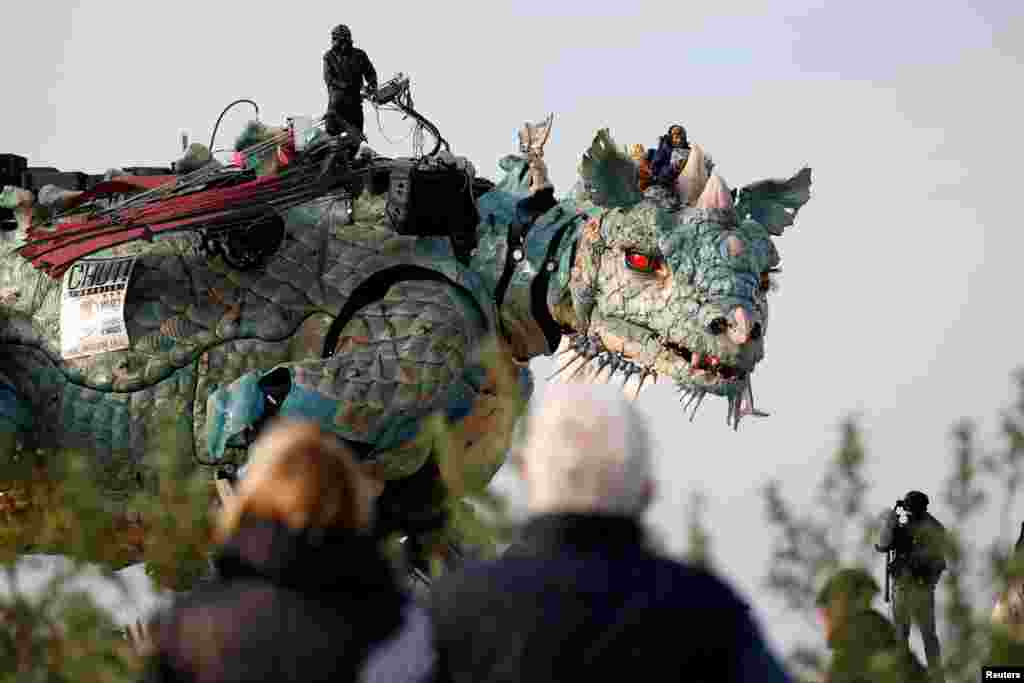 People look at the &quot;Dragon de Calais&quot; by Francois Delaroziere and La compagnie La Machine during a rehearsal in the harbor of Calais, France, Oct. 30, 2019.
