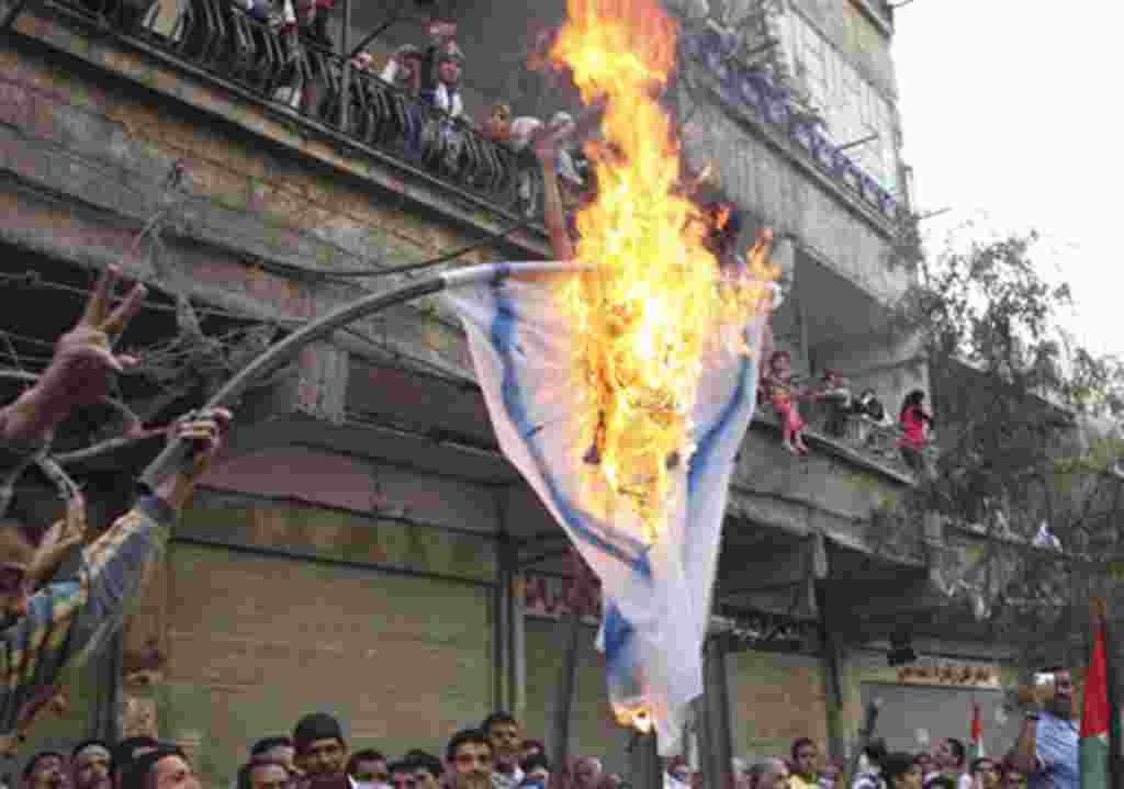 Palestinian mourners burn an Israeli flag during a funeral procession of three Palestinians who killed when Israeli soldiers opened fire on Sunday at protesters at Syria's border with the Israeli-controlled Golan Heights, May 16 2011