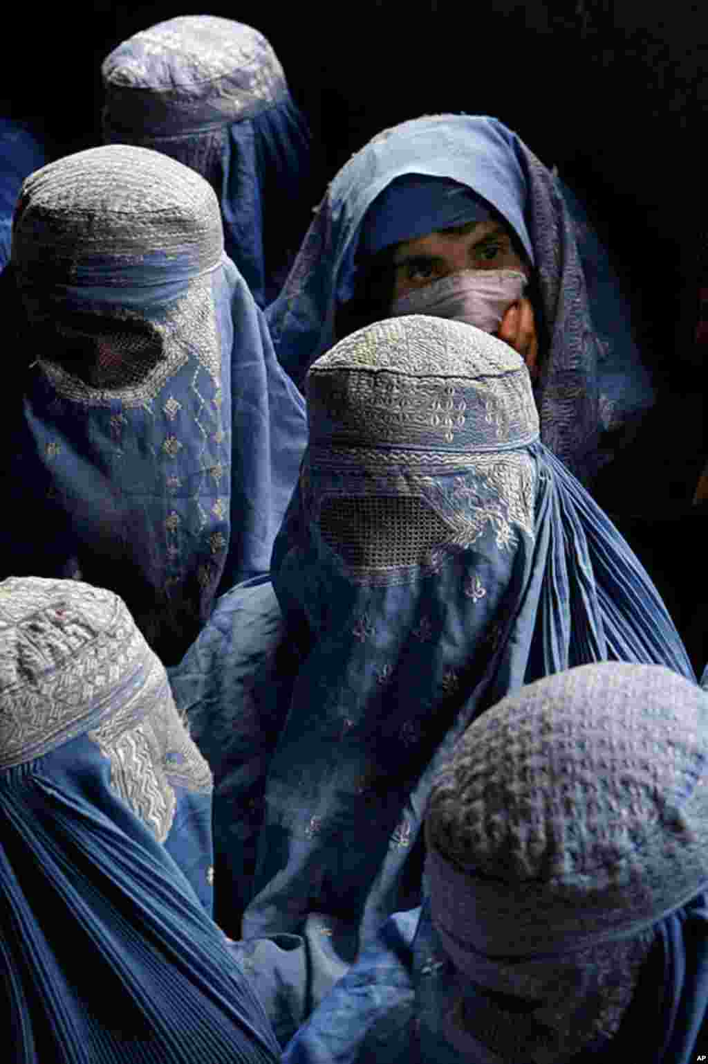 In an early celebration of International Women's Day 2005, a group of Afghan refugee women wait to receive gifts distributed by U.S. Corps of Engineers employees and soldiers from Combined Forces Command on March 4, 2005. Rights groups in the run-up to In
