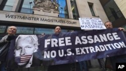 Beberapa demonstran melakukan unjuk rasa menentang upaya deportasi terhadap pendiri WikiLeaks Julian Assange, dalam aksi di London (13/1). 