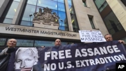 Demonstrators stand outside Westminster Magistrates Court in London in support of WikiLeaks founder Julian Assange, Jan. 13, 2020.