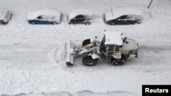 A bulldozer clears snow during a heavy snowfall in Madrid, Spain, Jan. 9, 2021. 