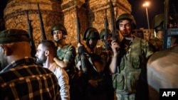 Turkish solders stay with weapons at Taksim Square as people protest against the military coup in Istanbul, July 16, 2016. 