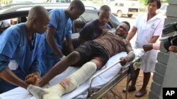 FILE - An injured man is helped at a private hospital after an alleged assault by a group of uniformed soldiers in Harare, Zimbabwe, Thursday, Jan. 17, 2019.