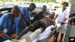 FILE: An injured man is helped at a private hospital after an alleged assault by a group of uniformed soldiers in Harare, Zimbabwe, Thursday, Jan. 17, 2019.