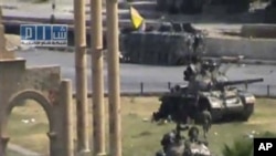 In this image made from amateur video released by the so-called Shams News Network, a loosely organized anti-Assad group and accessed via The Associated Press Television News on Monday, Aug. 1, 2011, military armored vehicles are seen in the central city 