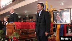 Presiden Iran Mahmoud Ahmadinejad berdiri di dekat peti jenazah Presiden Venezuela Hugo Chavez dalam upacara pemakaman di Caracas, Jumat (8/3). 