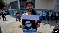 David Sosa, who was held at the political police SEBIN headquarters along with ex-mayor Daniel Ceballos and American citizen Joshua Holt, holds a poster of Ceballos outside the SEBIN headquarters and jail in Caracas, Venezuela, May 17, 2018.