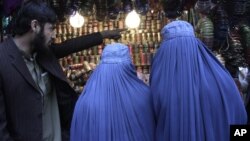 Afghan women shop at a market ahead of the upcoming Eid al-Adha, or the Feast of the Sacrifice, Jalalabad, Oct. 2012 file photo.