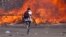 FILE - Zimbabwe's opposition supporters set up a burning barricade as they clash with police during a protest for electoral reforms, Aug. 26, 2016 in Harare, Zimbabwe.