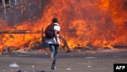 Zimbabwe's opposition supporters set up a burning barricade as they clash with police during a protest for electoral reforms, Aug. 26, 2016 in Harare, Zimbabwe.