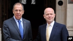 British Foreign Secretary William Hague, right, greets Russian Foreign Minister Sergei Lavrov as he arrives at the Foreign and Commonwealth Office for a bilateral meeting, in London, February 15, 2011