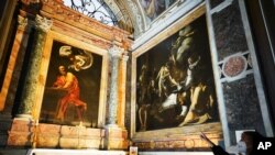 ARCHIVO - Una mujer señala una serie de pinturas del artista italiano del Siglo XVI, MIchelangelo Merisi, conocido como Caravaggio, en la capilla Contarelli de la Iglesia de San Luigi dei Francesi, en Roma, el 11 de diciembre de 2020. 