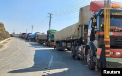 Truk-truk bermuatan perbekalan berangkat ke Afghanistan terdampar setelah otoritas Taliban menutup penyeberangan perbatasan utama di Torkham, Pakistan, 21 Februari 2023. (Foto: REUTERS/Shahid Shinwari)
