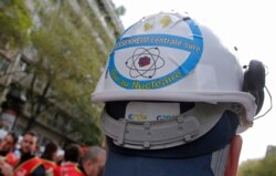 FILE - A sticker is photographed on a helmet of an employee of Fessenheim's nuclear power plant opposing the closure, during a protest outside the EDF headquarters in Paris, France, April 6, 2017.