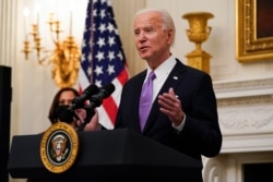 President Joe Biden speaks about the coronavirus, accompanied by Vice President Kamala Harris, in the State Dinning Room of the White House, Jan. 21, 2021, in Washington.