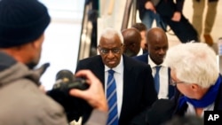 Former president of the IAAF (International Association of Athletics Federations) Lamine Diack, center, arrives at the Paris courthouse, Jan. 13, 2020.